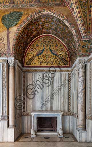 Palermo, The Royal Palace or Palazzo dei Normanni (Palace of the Normans), Pisana Tower,  the King Roger Room: view of the Room which was commissioned by King Roger II d'Altavilla. It is characterized by large mosaic surfaces of great value representing plant elements (palms and banana trees) and scenes of courtly and hunting style, symbols of the Norman power (hunting scenes with archers and deer, peacocks, swans, and mythological centaurs, griffins and other exotic animals including leopards and tigers among luxuriant vegetation). Mosaics are characterised by Greek Byzantiene style (XIII century).Detail of a niche with fireplace with two lion sculptures supporting the shelf; a lunette with a mosaic representing peacocks; rich marble coverings and angular columns.