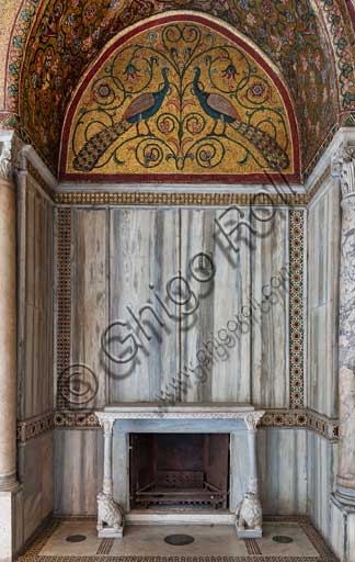 Palermo, The Royal Palace or Palazzo dei Normanni (Palace of the Normans), Pisana Tower,  the King Roger Room: view of the Room which was commissioned by King Roger II d'Altavilla. It is characterized by large mosaic surfaces of great value representing plant elements (palms and banana trees) and scenes of courtly and hunting style, symbols of the Norman power (hunting scenes with archers and deer, peacocks, swans, and mythological centaurs, griffins and other exotic animals including leopards and tigers among luxuriant vegetation). Mosaics are characterised by Greek Byzantiene style (XIII century).Detail of a niche with fireplace with two lion sculptures supporting the shelf; a lunette with a mosaic representing peacocks; rich marble coverings and angular columns.