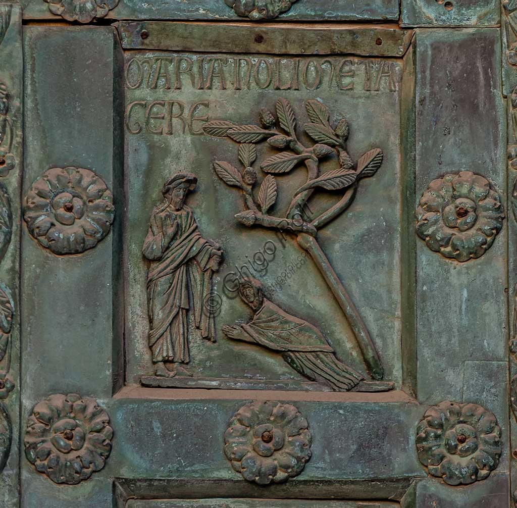 Duomo di Monreale, Porta di Bonanno Pisano (1185-6): formella bronzea con "Noli me tangere" (scena dal Nuovo Testamento).La porta è firmata: "Bonanno civis pisanus". Iconograficamente nei cinque ordini inferiori vi sono scene del Vecchio Testamento, sette dedicate alla storia di Adamo ed Eva, e altre sei ad altrettante coppie di profeti mentre nei cinque superiori scene del Nuovo, al sommo Cristo e Maria nella gloria del Paradiso.