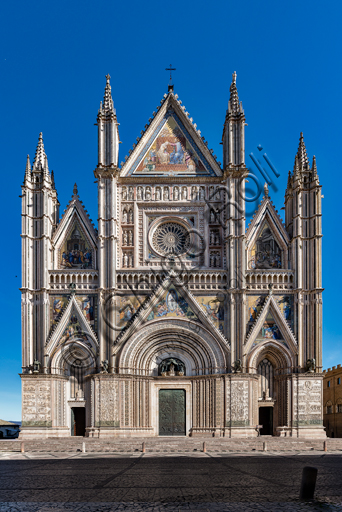 Orvieto, Basilica Cattedrale di Santa Maria Assunta (o Duomo): la facciata, iniziata alla fine del XIII secolo. Il disegno tricuspidale venne progettato da Lorenzo Maitani ed eseguito dallo stesso Maitani con l'aiuto di maestranze pisane e senesi (1320 -30). L'esecuzione fu continuata da Andrea Pisano (1347) e dall'Orcagna (1359) a cui si deve il rosone. 