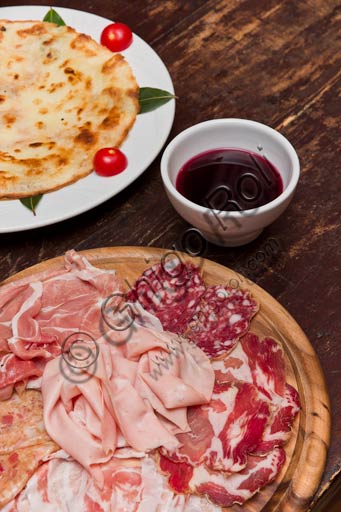 Osteria La Carrozza:  tagliere di salumi tipici piacentini, piatto con una bortellina (una sorta di crepe senza uova) e vino rosso dei Colli piacentini.
