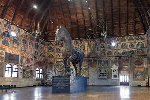 Padua, Palazzo della Ragione : the "Salone" (about 80 meters long and 27 meters wide)  is covered by a wooden structure almost 40 meters high. The wooden horse was donated to the City by the family Capodilista  in 1837. The horse had been made for a tournament in 1466. The frescoes were painted by John Miretto and by an unknown artist from Ferrara in the first half of the fifteenth century . The themes are the Zodiac, the trades of the year. There are also frescoes about religious themes.