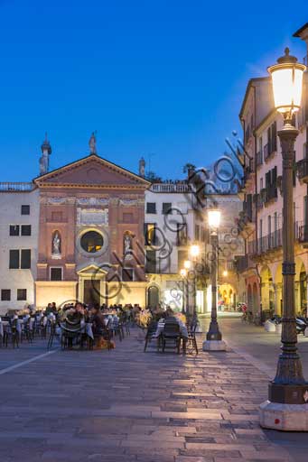   Padua, Piazza dei Signori or Piazza della Signoria: night view with people sitting at bar tables. In the background, the Church of St. Clemente. You can also distinguish a partial view of Palazzo della Ragione.