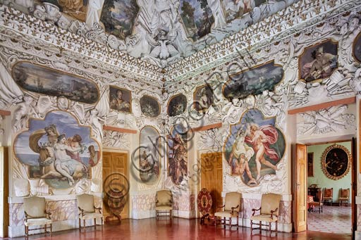 Parma, Soragna, Rocca Meli Lupi: veduta della Sala degli Stucchi,  grande Salone quadrato la cui fastosa decorazione, perfetta testimonianza del più caratteristico barocco di fine '600, è dovuta all'opera di Ferdinando e Francesco Galli, detti i 'Bibiena', che hanno dipinto il soffitto con scene della gloriosa storia della famiglia Meli Lupi e delle loro vittorie contro gli ottomani, sia al servizio dell'Impero, sia della Repubblica Veneta (ai quattro angoli della Sala sono presenti, alternati, i simboli dell'Aquila imperiale e del Leone di San Marco sopra una testa di turco). Pregevoli le pitture contornate da stucchi, sempre opera dei Bibiena, nonché le scene di gusto classico che ornano le pareti dello stesso salone.