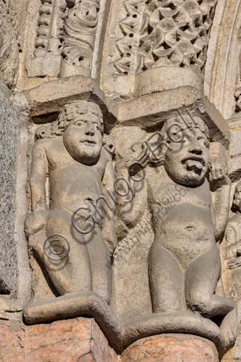 Piacenza, the Cathedral (Duomo),  façade, let portal: telamone depicting vices and virtues, artwork by workers from Nonantola (MO). A man and a woman tearing their hair out: symbol of Mankind living outside the Faith.