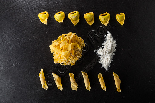 Piatto di tagliatelle, tortelloni e garganelli crudi e farina. 