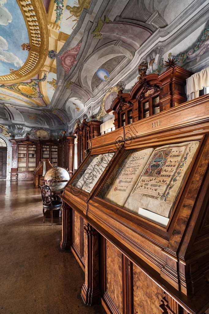 Pontificia Biblioteca Antoniana: veduta del Salone con mappamondo, librerie  e mobili contenenti corali miniati.