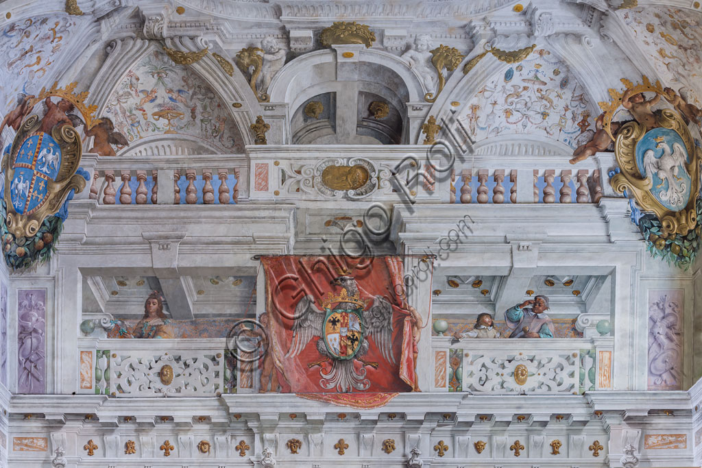 Sassuolo, Este Ducal Palace; Hall of the Guards:  the hall with the “Bologna Quarters” by Angelo Michele Colonna, Agostino Mitelli, Baldassarre Bianchi and Gian Giacomo Monti. Detail of the south-west wall, with the coat of arms of the Este family and a balcony with figures, including a man with glasses.