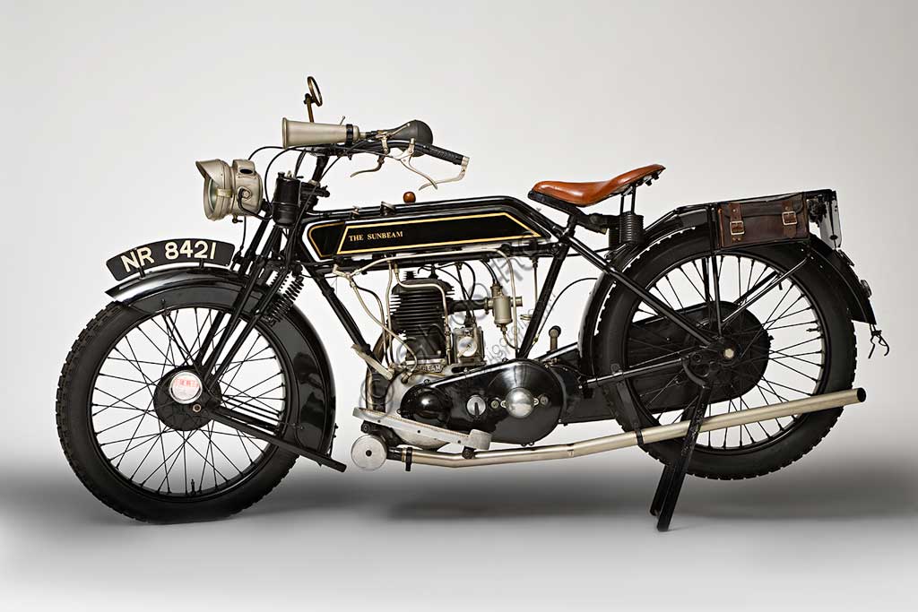 Moto d'epoca Sunbeam Model 5 Lusso 500Marca: Sunbeammodello: Model 5Lusso 500nazione: Regno Unito - Wolverhamptonanno: 1926condizioni: restauratacilindrata: 492 cc. (alesaggio e corsa 77 x 105,5)motore: monocilindrico a valvole lateralicambio: a tre velocitàJohn Marston, il fondatore della Sunbeam dal carattere severo, dopo aver iniziato come produttore di stoviglie smaltate, continuò come costruttore di biciclette, ma non guidò mai una moto nè un'automobile che giudicava troppo pericolose...Nonostante questo il suo perfezionismo si riflette nella alta qualità di tutte la produzione Sunbeam. Infatti le sue moto, che furono sempre più care delle altre, ebbero un loro fedele pubblico di estimatori. Il dettaglio qui raffigurato, del carter della catena con vaschetta interna per la lubrificazione, è un esempio di questa cura del dettaglio.Questa Model 5 è uno dei modelli più rappresentativi del periodo d'oro della Sunbeam. Dopo il '30 inizia un lungo declino che vede la Sunbeam prima assorbita dal gruppo AMC, poi dalla BSA e infine, nel 1964, chiusa.