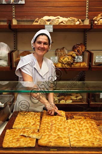  Recco, Moltedo traditional bakery: Luisa Moltedo is cutting a piece of focaccia bread.