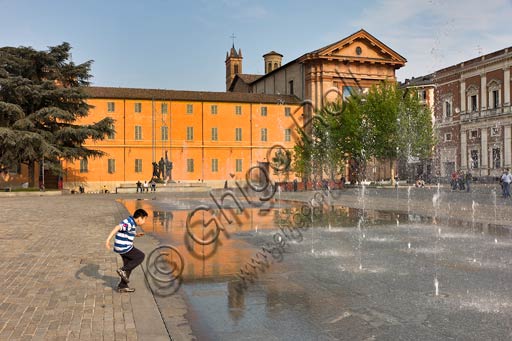 Reggio Emilia, Martiri del 7 luglio Square: a young boy playing with a ball. In the background, the St. Francis Church.