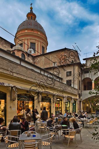 Reggio Emilia, Prampolini Square: night view of the Broletto. People sitting at bar tables.