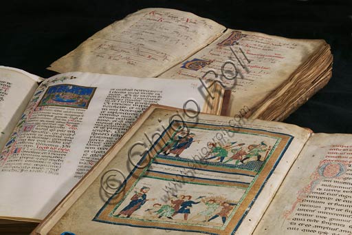 Modena, Duomo, Archivio Capitolare: alcuni tra i volumi più rappresentativi dell'Archivio Capitolare, tra cui la "Relatio de innovatione ecclesiae sancti Geminiani", dell'inizio XII secolo, cod. II.11, dove si vede l'architetto Lanfranco che dirige le maestranze nella costruzione del Duomo.