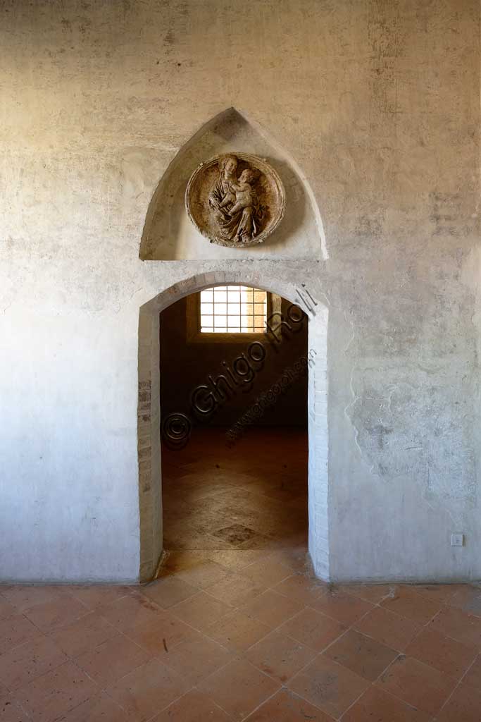 Vignola Stronghold: the door to the Contrari Chapel. In the niche, there is a tondo in scagliola (fifteenth-century style), depicting a Madonna with Child, in the variant called Madonna of Humility.