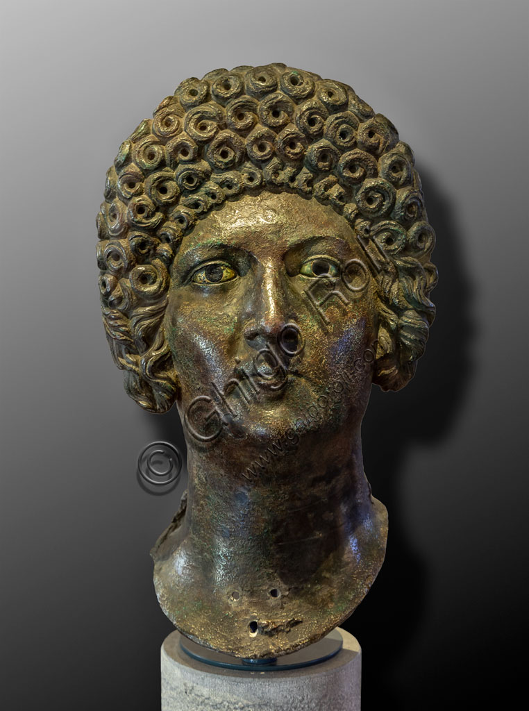 Brescia, "Santa Giulia, Museo della Città" (sito Unesco dal 2011): ritratto di donna appartenente alla famiglia dei Flavi, bronzo, fusione in cera persa, seconda metà del I secolo d. C. La ricca capigliatura a riccioli, spesso ottenuta con parrucche, è quella tipica delle donne della famiglia dei Flavi. Potrebbe trattarsi di Domizia Longina, moglie dell'Imperatore Domiziano, o di Giulia, figlia dell'Imperatore Tito.Si tratta di uno dei sei ritratti romani trovati nel 1826 presso il Capitolium dell'antica Brixia.