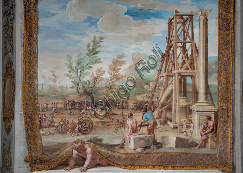 Sassuolo, Este Ducal Palace, the Bacchus Gallery: “Raising the Columns on the River Ganges”.The faux tapestry from which a putto peeks out depicts a vast river landscape dominated in the foreground by the scaffolding of the two Corinthian columns. Bacchus, seated on a boulder, observes the numerous workers with ropes and winches. It is one of the forty-one panels with scenes painted by Jean Boulanger which narrate the events of Bacchus. Wall tempera painting, 1650 - 52.Detail.