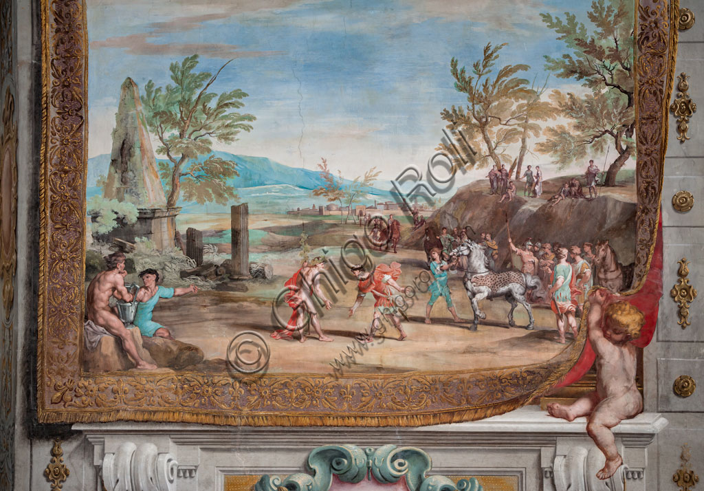 Sassuolo, Este Ducal Palace, the Bacchus Gallery: “The meeting in Egypt of Proteus, king of Memphis, with Bacchus”. The faux tapestry depicting a landscape with classical ruins is lifted on the right by a putto. In the centre, engaged in obsequious ceremonies, Bacchus and Proteus, king of Memphis. On the left two characters observe the scene and on the right other characters carry a white horse. It is one of the forty-one panels with scenes painted by Jean Boulanger which narrate the events of Bacchus. Wall tempera painting, 1650 - 52.
