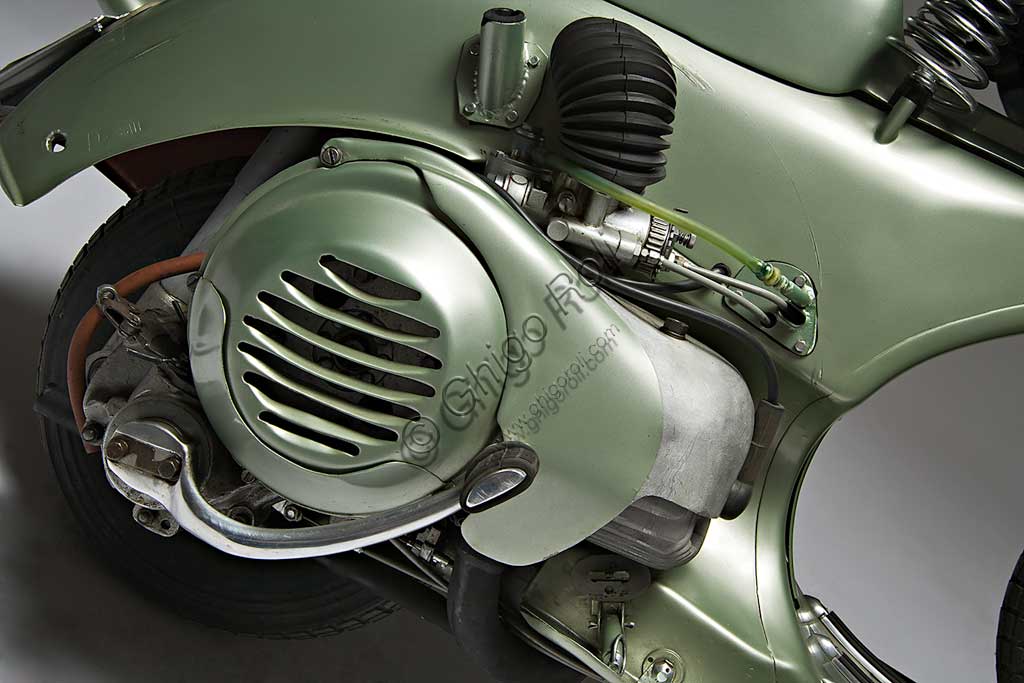 Moto d'epoca Vespa Sei Giorni. Scooter.Marca: Piaggiomodello: Vespa "Sei Giorni"nazione: Italia - Genova - Pontederaanno: 1951condizioni: restauratacilindrata: 124,2motore: monocilindrico a due tempicambio: al manubrio a tre rapportiLa Vespa, che apparve per la prima volta nel 1946, è in produzione ancor oggi ed è il motoveicolo più longevo della storia. Ne sono stati prodotti oltre 16 milioni di esemplari in 140 modelli. Venne concepita già durante la guerra e, dopo un primo prototipo denominato "Paperino", non particolarmente riuscito, Enrico Piaggio ne affidò il progetto a Corradino d'Ascanio, ingegnere aeronautico. Le soluzioni anticonformiste e geniali da lui adottate, oltre al grande bisogno di veicoli a basso costo che aveva l'Italia nel dopoguerra, ne decretarono un progressivo crescente successo, fino a farne, anche attraverso l'immagine che il cinema di quegli anni ne diffondeva, uno dei simboli dell'Italia. La "Sei Giorni" di queste pagine è uno dei modelli più rari.  Concepita per le corse, vinse nove medaglie d'oro all'olimpiade motociclistica del 1951, la "Sei Giorni Internazionale" di Varese.