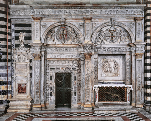 Siena, Duomo (Cathedral): the exterior of the Piccolomini Library. with the marble façade by Lorenzo di Mariano Fucci, known as  Marrina e Giovanni di Stefano, 1497-99.  On the left, “the funerary monument to Bandini e Germanico Bandini”, by XVI century Siena sculptors.