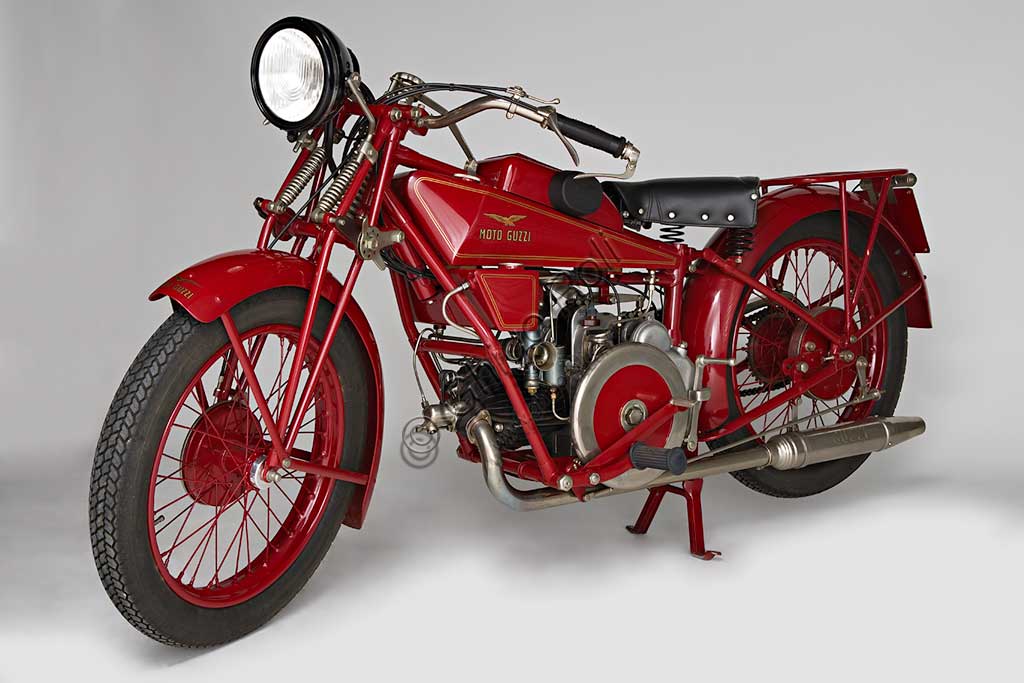 Moto d'epoca Guzzi Sport 14.Marca: Moto Guzzimodello: Sport 14nazione: Italia - Mandello Larioanno: 1929condizioni: restauratacilindrata: 498,4 cc (Alesaggio e corsa 88 x 82)motore: quattro tempi monocilindrico orizzontalecambio: in blocco a tre rapportiLa Sport 14, ultima Guzzi con serbatoio "sottocanna", si colloca come modello di transizione tra la prima Tipo Normale e i modelli di grande successo degli anni trenta. Nonostante il nome Sport, nasce come modello prevalentemente votato al turismo e si rivolge a quel pubblico ormai affezionato alla casa, che cerca moto robuste e affidabili da usare ogni giorno e anche nei viaggi più impegnativi. Una rapida occhiata ai comandi è sufficiente per capire cosa significasse guidare le moto degli anni '20: al manubrio troviamo le tre manette di gas, aria e anticipo, le tre leve di frizione, alzavalvole e freno anteriore, il pomello del frenasterzo;  al lato del serbatoio la leva del cambio, poi i pedali del freno posteriore, il rubinetto dell'olio, il rubinetto della benzina e il cicchetto, oltre naturalmente a tutti i comandi elettrici....