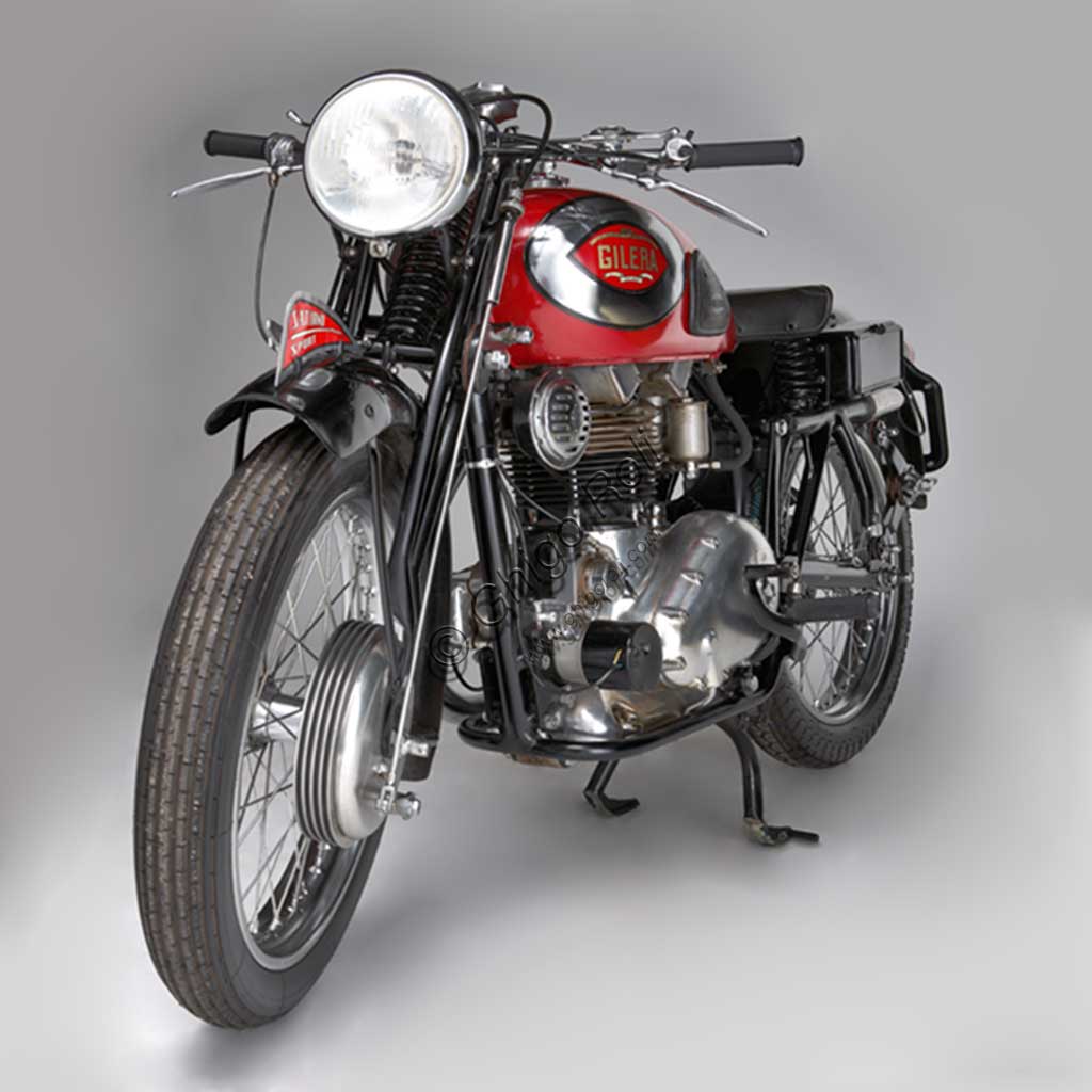 Moto d'epoca Guzzi Sport 14.Marca: Moto Guzzimodello: Sport 14nazione: Italia - Mandello Larioanno: 1929condizioni: restauratacilindrata: 498,4 cc (Alesaggio e corsa 88 x 82)motore: quattro tempi monocilindrico orizzontalecambio: in blocco a tre rapportiLa Sport 14, ultima Guzzi con serbatoio "sottocanna", si colloca come modello di transizione tra la prima Tipo Normale e i modelli di grande successo degli anni trenta. Nonostante il nome Sport, nasce come modello prevalentemente votato al turismo e si rivolge a quel pubblico ormai affezionato alla casa, che cerca moto robuste e affidabili da usare ogni giorno e anche nei viaggi più impegnativi. Una rapida occhiata ai comandi è sufficiente per capire cosa significasse guidare le moto degli anni '20: al manubrio troviamo le tre manette di gas, aria e anticipo, le tre leve di frizione, alzavalvole e freno anteriore, il pomello del frenasterzo;  al lato del serbatoio la leva del cambio, poi i pedali del freno posteriore, il rubinetto dell'olio, il rubinetto della benzina e il cicchetto, oltre naturalmente a tutti i comandi elettrici....