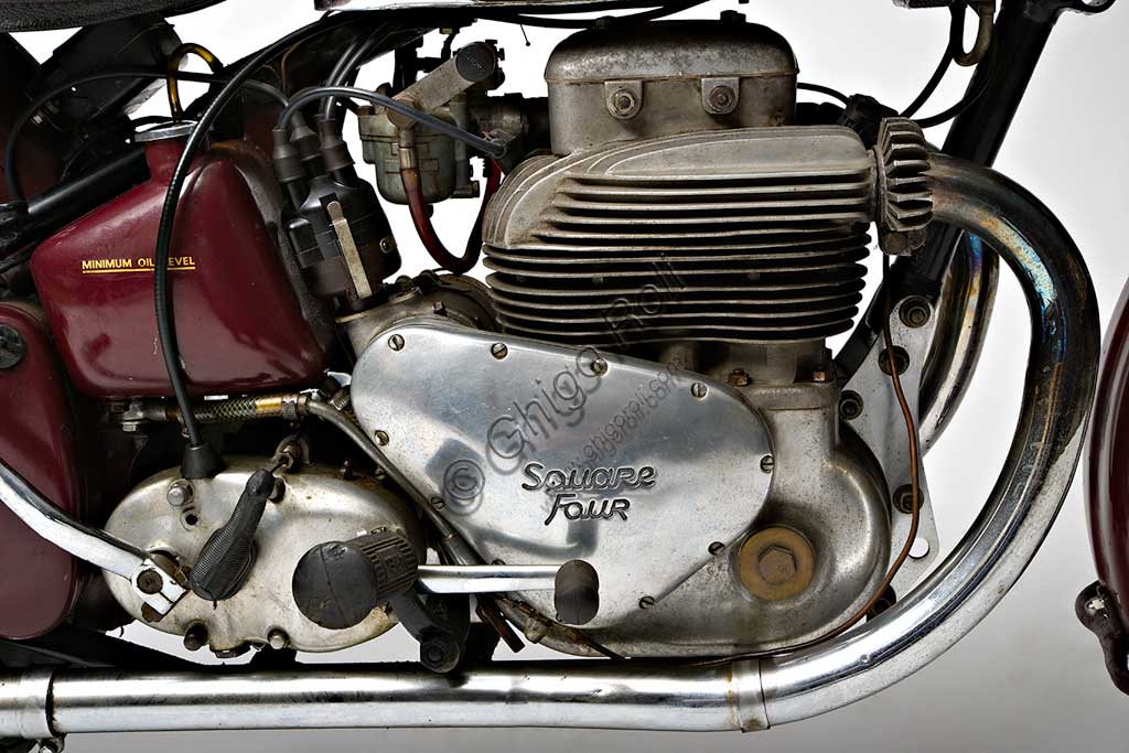 Moto d'epoca Ariel Square Four Mk1. Motore.Marca: Arielmodello: Square Four Mk1nazione: Regno Unito - Birminghaanno: 1950condizioni: conservatacilindrata: 995 cc (alesaggio e corsa 65 x 75)motore: quattro cilindri "square"cambio: a quattro rapportiGià conosciuto come marchio di biciclette a metà ottocento, l'evocativo nome di Ariel, spirito shakespeariano, ricompare nel 1901 legato alla prima motocicletta di una lunga serie, che monta un motore di 211 cc. La fabbrica di Birmingham produce molti mono e qualche bicilindrico, fino al 1931 quando, su disegno di Edward Turners, nasce lo "Square Four" un motore poi divenuto mitico. Con doppio albero motore parallelo e quattro cilindri disposti in quadrato, il suo progetto rimane unico nel panorama motociclistico mondiale.Questo propulsore deve la sua fama anche a una elasticità e a un "tiro" ai bassi proverbiali, al punto da far quasi diventare inutile il cambio a quattro marce. Il modello qui presentato è del 1950, l'ultimo anno in cui comparivano due soli tubi di scarico: i cilindri posteriori infatti, conferivano i gas combusti nel collettore di quelli anteriori all'interno della testa. Fu prodotta fino al '59.