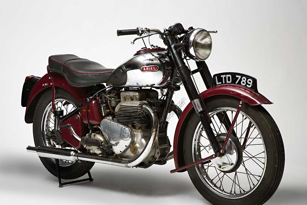 Moto d'epoca Ariel Square Four Mk1Marca: Arielmodello: Square Four Mk1nazione: Regno Unito - Birminghaanno: 1950condizioni: conservatacilindrata: 995 cc (alesaggio e corsa 65 x 75)motore: quattro cilindri "square"cambio: a quattro rapportiGià conosciuto come marchio di biciclette a metà ottocento, l'evocativo nome di Ariel, spirito shakespeariano, ricompare nel 1901 legato alla prima motocicletta di una lunga serie, che monta un motore di 211 cc. La fabbrica di Birmingham produce molti mono e qualche bicilindrico, fino al 1931 quando, su disegno di Edward Turners, nasce lo "Square Four" un motore poi divenuto mitico. Con doppio albero motore parallelo e quattro cilindri disposti in quadrato, il suo progetto rimane unico nel panorama motociclistico mondiale.Questo propulsore deve la sua fama anche a una elasticità e a un "tiro" ai bassi proverbiali, al punto da far quasi diventare inutile il cambio a quattro marce. Il modello qui presentato è del 1950, l'ultimo anno in cui comparivano due soli tubi di scarico: i cilindri posteriori infatti, conferivano i gas combusti nel collettore di quelli anteriori all'interno della testa. Fu prodotta fino al '59.