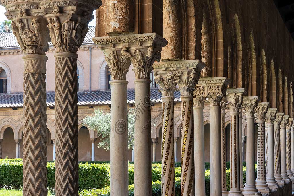 Monreale, Duomo, chiostro del monastero benedettino (XII secolo): fuga di colonne e capitelli sul lato Nord; in primo piano il capitello N24, faccia Nord-Ovest; "Strage degli Innocenti".