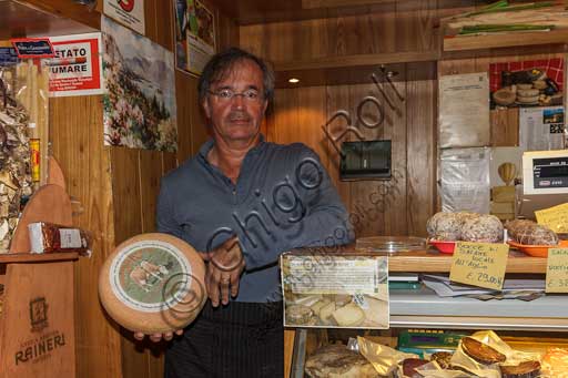 Stresa, Latteria Coppola: il proprietario mostra una forma di formaggio tipico del Mottarone