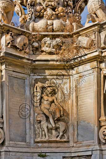 Palermo, the Parliament Square: The Marble Theatre, monument to Philip V, facing The royal Palace or Palace of the Normans. It was realised by Gaspare Guercio, Carlo D'Aprile and Gaspare Serpotta to celebrate the glory of Philip IV of Habsburg, king of Spain and Sicily, called Philip the Great.Around the pedestal  the four parts of the Earth known at that time (Europe, Asia, Africa and America), on which the king of Spain ruled, are depicted. On the first level there are the statues of the four Moors, or the previous kings of the countries that went under his domination. The work is adorned with plaques and coats of arms of the most important families in Sicily. The original statue of Philip IV was destroyed during the Sicilian revolution in 1848 and was replaced in 1856 by the current marble statue representing King Philip V of Spain and was realised by Nunzio Morello.Detail.