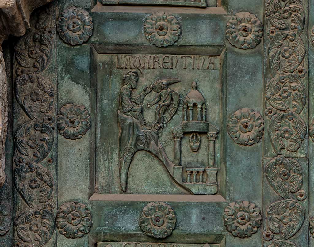 Duomo di Monreale, Porta di Bonanno Pisano (1185-6): formella bronzea con "La Tentazione di Cristo" (scena dal Nuovo Testamento).La porta è firmata: "Bonanno civis pisanus". Iconograficamente nei cinque ordini inferiori vi sono scene del Vecchio Testamento, sette dedicate alla storia di Adamo ed Eva, e altre sei ad altrettante coppie di profeti mentre nei cinque superiori scene del Nuovo, al sommo Cristo e Maria nella gloria del Paradiso.