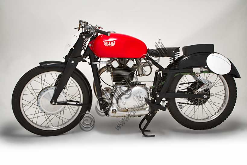 Moto d'epoca “Gilera Saturno Sanremo”Marca: Gileramodello: Saturno Sanremo (Corsa Ufficiale Casa)nazione: Italia - Arcoreanno: 1947 - 8condizioni: restauratacilindrata: 498,7 (alesaggio e corsa 84 x 90)motore: monocilindrico cambio: a quattro rapportiDerivata direttamente dai modelli anteguerra VT e VTE, conosciuti come "Quattro Bulloni" e "Otto Bulloni" la Saturno fu progettata dall'Ing. Giuseppe Salmaggi che ne disegnò ogni particolare, tra cui quel basamento curvilineo che, per gli estimatori della Casa, è un vero capolavoro. La Saturno fu il modello di maggior successo della Gilera e, fra tutte le Saturno, la Sanremo è la più rara, ricercata dai collezionisti e riprodotta dai falsari. Prende il nome dal circuito dove vinse per quattro edizioni consecutive, dal debutto del '47. Nonostante i trionfi dei quattro cilindri, la Gilera tenne in produzione il Sanremo per molti anni grazie alla sua maggiore agilità nei circuiti tortuosi e alla grande coppia a qualsiasi régime. Questa moto regalò un numero sconfinato di vittorie a Nello Pagani e Umberto Masetti, ambedue campioni del mondo, e ancora a Clemencigh, Milani, Bandirola....