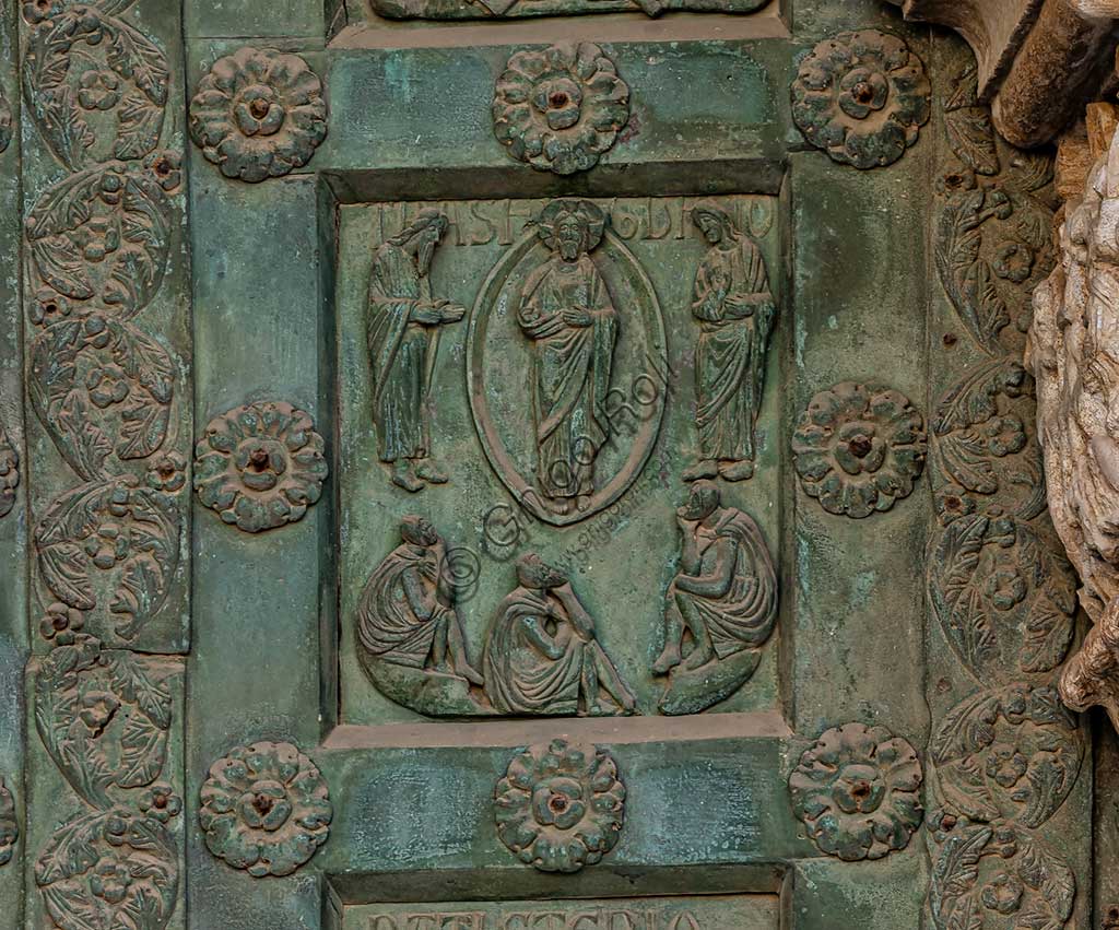 Duomo di Monreale, Porta di Bonanno Pisano (1185-6): formella bronzea con "Trasfigurazione di Gesù sul Monte Tabor" (scena dal Nuovo Testamento).La porta è firmata: "Bonanno civis pisanus". Iconograficamente nei cinque ordini inferiori vi sono scene del Vecchio Testamento, sette dedicate alla storia di Adamo ed Eva, e altre sei ad altrettante coppie di profeti mentre nei cinque superiori scene del Nuovo, al sommo Cristo e Maria nella gloria del Paradiso.