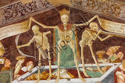  Clusone, Oratory of Disciplini or St. Bernardino, façade: frescoes with the Triumph of Death on the top and a Dance of Death (Macabre Dance) in the lower register (1485). All the frescoes are by Giacomo Borlone De Buschis.Detail of the Triumph of Death standing on a sarcophagus where the dead Pope and the Emperor lie. Theay are surrounded by serpents, scorpions and toads (symbols of pride and sudden death). Death hold big scrolls to remind everyone that Life is not everlasting.