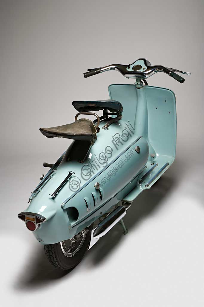 Moto d'epoca Prina Orix 175 GL. Scooter.Marca: Prinamodello: Orix 175 GL(Gran Lusso)nazione: Italia - Astianno: 1953condizioni: conservato come nuovocilindrata: 174,2 (alesaggio e corsa 58 x 66)motore: JLO monocilindrico a due tempicambio: in blocco a quattro rapporti con comando a pedaleAntonio "Tunin" Prina, astigiano, tentò nel dopoguerra, come molti suoi colleghi, il salto dalla produzione di biciclette a quella delle motoleggere e degli scooter. Lo fece alla grande, scegliendo per il suo scooter la sigla Gran Lusso e dotandolo di quanto di meglio si poteva chiedere allora: ruote di tipo motociclistico a  raggi e di grande diametro, telaio monotrave in acciaio di grande rigidità, scocche della carrozzeria dalle forme ricercate e avveniristiche, cromature in abbondanza. Il prezzo era di conseguenza: 265.000 Lire di listino nel 1952, quando la Lambretta ne costava 166.000 e la Vespa 150.000. Per quanto l'Orix potesse essere ritenuto bello il prezzo era troppo alto perchè  avesse successo. Non lo ebbe allora, è molto ricercato oggi.