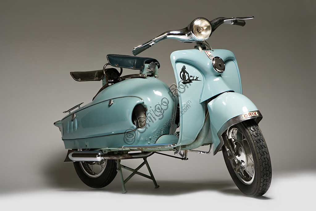 Moto d'epoca Prina Orix 175 GL. Scooter.Marca: Prinamodello: Orix 175 GL(Gran Lusso)nazione: Italia - Astianno: 1953condizioni: conservato come nuovocilindrata: 174,2 (alesaggio e corsa 58 x 66)motore: JLO monocilindrico a due tempicambio: in blocco a quattro rapporti con comando a pedaleAntonio "Tunin" Prina, astigiano, tentò nel dopoguerra, come molti suoi colleghi, il salto dalla produzione di biciclette a quella delle motoleggere e degli scooter. Lo fece alla grande, scegliendo per il suo scooter la sigla Gran Lusso e dotandolo di quanto di meglio si poteva chiedere allora: ruote di tipo motociclistico a  raggi e di grande diametro, telaio monotrave in acciaio di grande rigidità, scocche della carrozzeria dalle forme ricercate e avveniristiche, cromature in abbondanza. Il prezzo era di conseguenza: 265.000 Lire di listino nel 1952, quando la Lambretta ne costava 166.000 e la Vespa 150.000. Per quanto l'Orix potesse essere ritenuto bello il prezzo era troppo alto perchè  avesse successo. Non lo ebbe allora, è molto ricercato oggi.