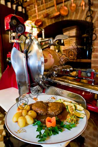  Verona Tre Marchetti Restaurant:a plate of stew made with Amarone wine. In the backgorund, a slicer.