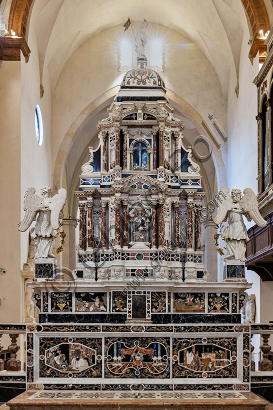 Vicenza, Chiesa di Santa Corona: l’altare maggiore (1669), provvisto di due mense, sormontate da grandioso tabernacolo marmoreo. Le preziose tarsie in marmo e con commesso di pietre dure e pietre preziose sono opera del fiorentino Francesco Antonio Corbarelli (1670).